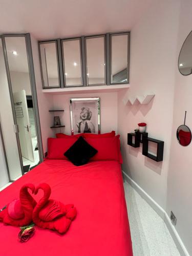 - une chambre avec un lit rouge et un oreiller pour le cœur dans l'établissement JOIA PARIS - Roli, à Paris
