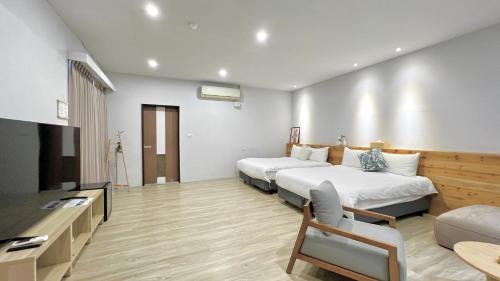 a hotel room with two beds and a flat screen tv at TokuGawa Hotel in Shuili
