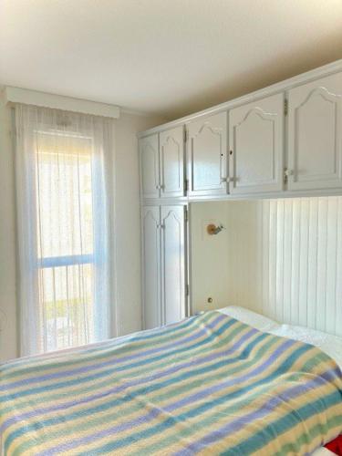 - une chambre avec un lit, des armoires blanches et une fenêtre dans l'établissement Deux pièce vue Mer et Port 4PP2B32, au Barcarès