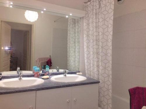 une salle de bain avec deux lavabos et un grand miroir dans l'établissement Calme pour cet appartement 4 personnes - résidence Piscine - parking privé - 4HAMCL2A, à Claira