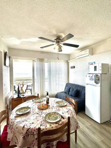 - un salon avec une table et un réfrigérateur blanc dans l'établissement Confortable T2 + Cabine face à la mer 4BALM39, au Barcarès