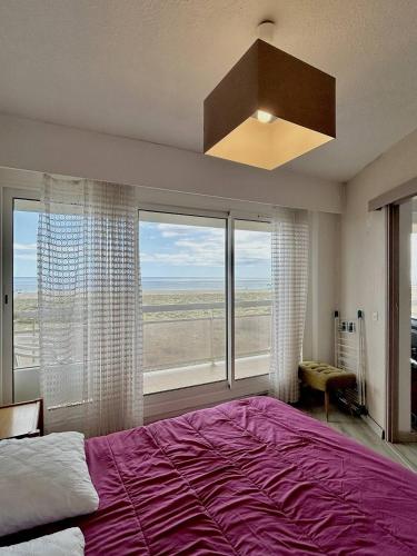 une chambre avec un grand lit et une grande fenêtre dans l'établissement Confortable T2 + Cabine face à la mer 4BALM39, au Barcarès