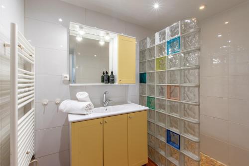 une salle de bain avec un lavabo et un miroir dans l'établissement Maison de plage Les Grenadines 50M de la MER Clim, à La Grande Motte