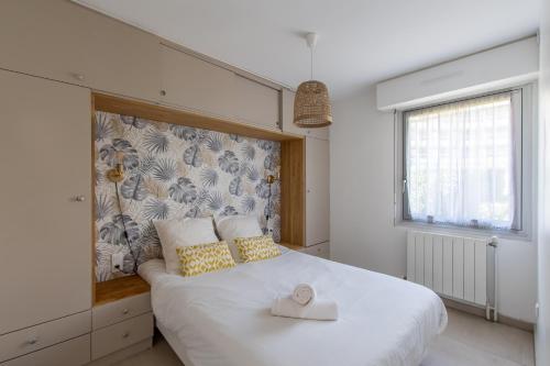 - une chambre avec un grand lit blanc et des oreillers jaunes dans l'établissement Maison de plage Les Grenadines 50M de la MER Clim, à La Grande Motte