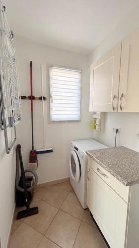 une petite cuisine avec un lave-linge. dans l'établissement SUPERBE appartement T3 - piscine- Terrasse- Parking- 900 m plage 6PIN2102, au Barcarès