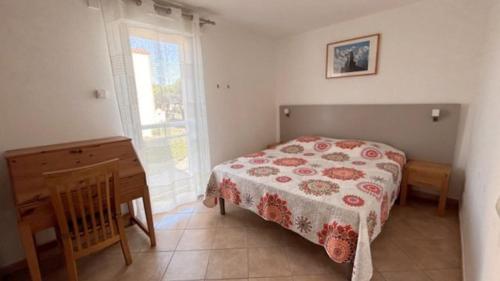 une chambre avec un lit, un bureau et une fenêtre dans l'établissement SUPERBE appartement T3 - piscine- Terrasse- Parking- 900 m plage 6PIN2102, au Barcarès