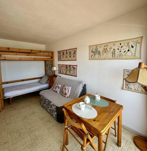 un salon avec une table et un lit dans l'établissement Studio accès direct plage - parking - Vue Mer 2PPECH31, au Barcarès