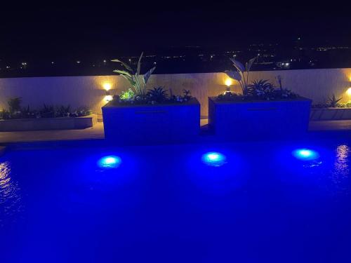 a patio with blue lights and potted plants at Deadsea Elite First floor shared swimming pool in Sowayma