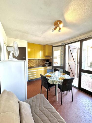 une cuisine et une salle à manger avec une table et un réfrigérateur dans l'établissement Accès direct plage - parking privé - appartement 4 personnes 4MIR7BAT8, au Barcarès