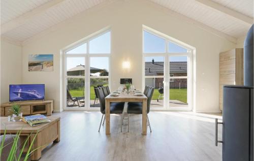 a dining room with a table and chairs and windows at Cozy Home In Dagebüll With Kitchen in Dagebüll