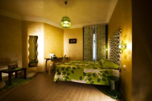 a bedroom with a bed with a green comforter at Domus Diana in Rome