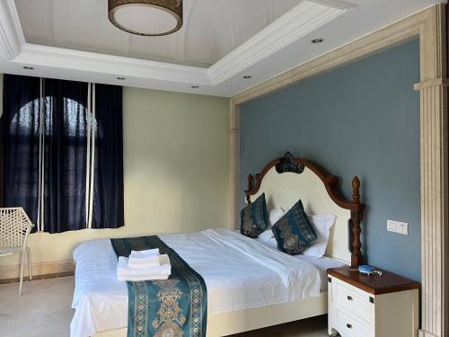 a bedroom with a bed and a window at Sanya beach sweet house in Luoyushangcun