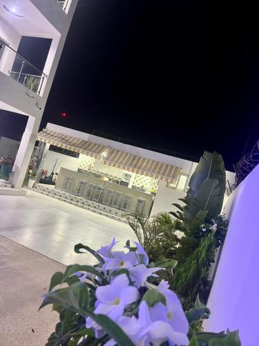 a building with purple flowers in front of a building at Résidence Turpin in Toubab Dialaw