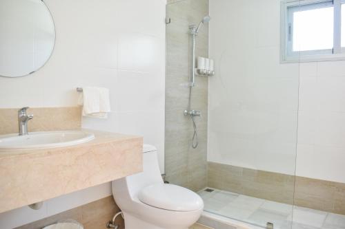 a bathroom with a toilet and a sink and a shower at Ka' Romana Residences in El Soco
