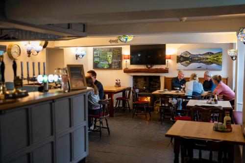 a group of people sitting at tables in a restaurant at Royal Hotel in Dockray