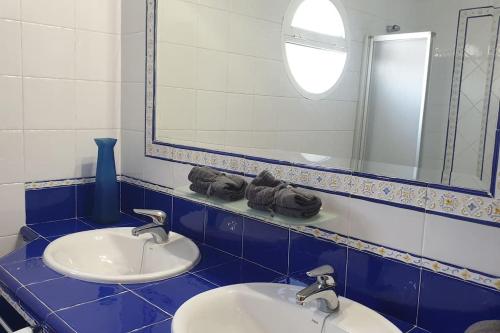 un bagno con due lavandini e uno specchio di Islantilla Urbasur 1 dormitorio y terraza a Islantilla