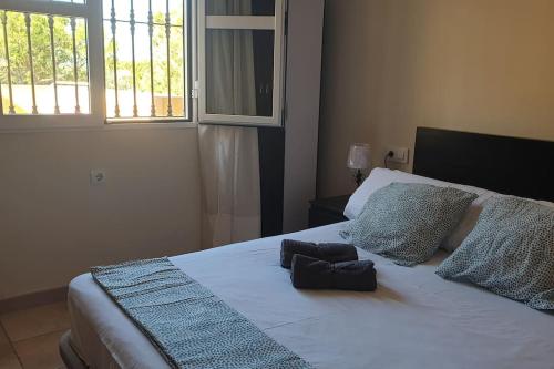 una camera da letto con un letto con due cuscini e una finestra di Islantilla Urbasur 1 dormitorio y terraza a Islantilla