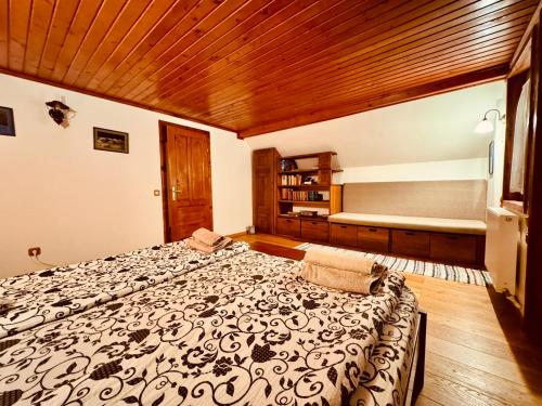 a bedroom with a bed and a wooden ceiling at Hillside Praid in Praid