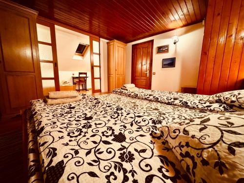 a bedroom with two beds with a black and white blanket at Hillside Praid in Praid