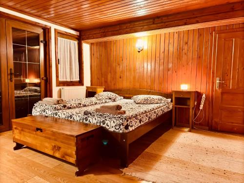 a bedroom with two beds and a wooden wall at Hillside Praid in Praid