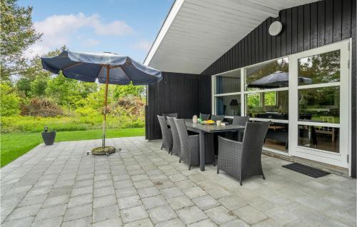a patio with a table and an umbrella at Holiday Home Filosofstræde Vi in Dannemare