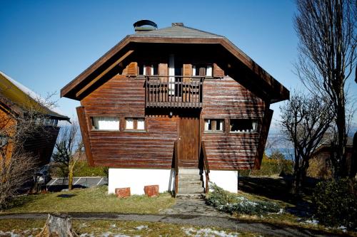 a large wooden building with a balcony on top at chalet haute-savoie in Thollon