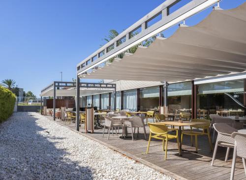 an outdoor dining area with tables and chairs at INNSiDE by Meliá Barcelona Aeropuerto in El Prat de Llobregat