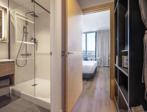 a bathroom with a shower and a bedroom at INNSiDE by Meliá Barcelona Aeropuerto in El Prat de Llobregat