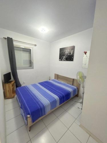 une chambre avec un lit bleu et une fenêtre dans l'établissement Appartement idéal pour famille vue sur la piscine 4GB217, au Barcarès