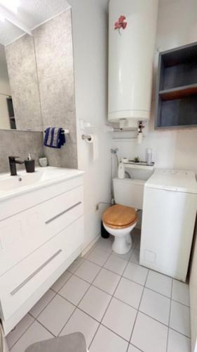 une salle de bain blanche avec des toilettes et un lavabo dans l'établissement Appartement idéal pour famille vue sur la piscine 4GB217, au Barcarès
