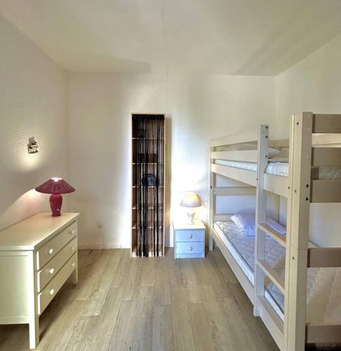 Cette chambre comprend 2 lits superposés, un bureau et une lampe. dans l'établissement Appartement dans un secteur calme proche de la plage 4MAR3R4, au Barcarès