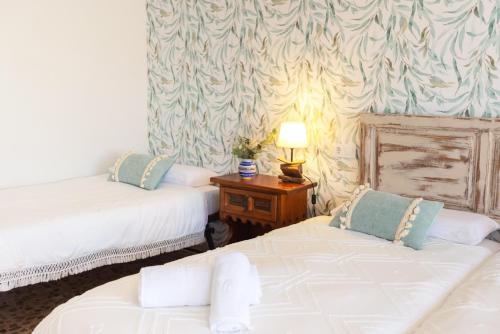 a room with two beds and a table with a lamp at Casa Rural Teralba 2 in La Calzada de Oropesa