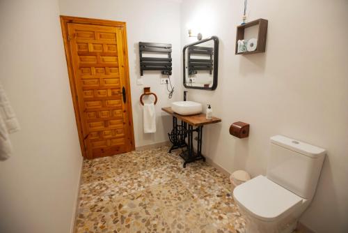a bathroom with a toilet and a sink and a mirror at Casa Rural Teralba 2 in La Calzada de Oropesa