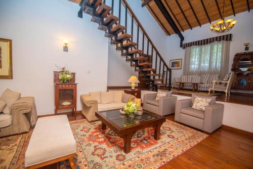 a living room filled with furniture and a wooden staircase at Manuel Manor in Labugolla