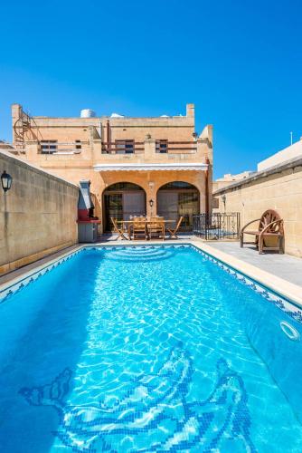 a swimming pool in front of a building at 4 Bedroom Holiday Home with Private Pool in Għarb