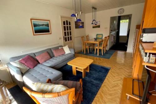 a living room with a couch and a table at Perfect Appartement - Dichtbij Zee en Natuur in Vlissingen