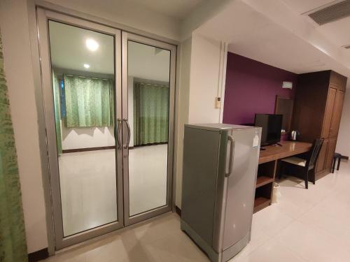 a kitchen with a refrigerator and a desk with a computer at Baan Manthana Hotel, Hua Hin in Hua Hin