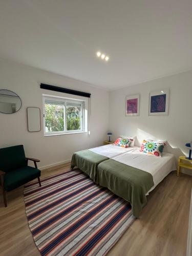a bedroom with a large bed and a rug at Casinha da Portela in Sintra