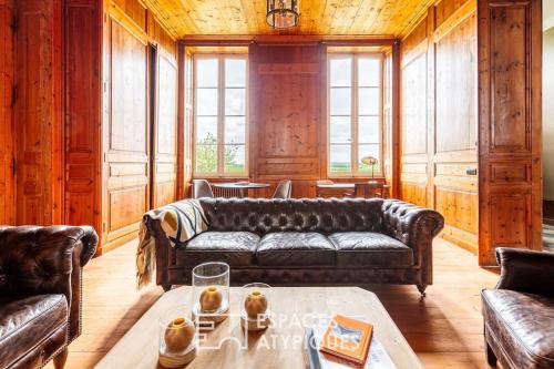 - un salon avec des canapés en cuir et une table dans l'établissement Domaine historique entre mer et campagne, à Dolus-d'Oléron