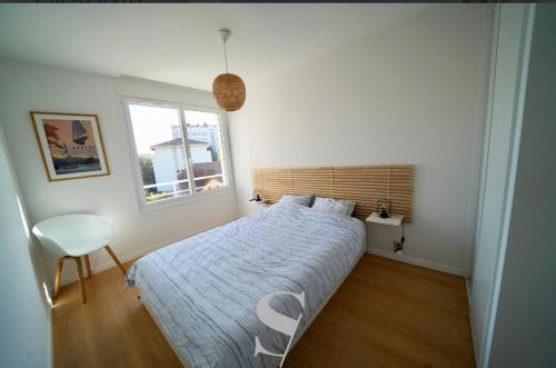 une chambre avec un lit, une fenêtre et une chaise dans l'établissement T2 proche lac, à Annecy