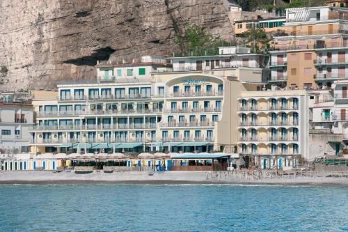 a large building on the beach next to the water at Alimuri Bay Resort in Meta