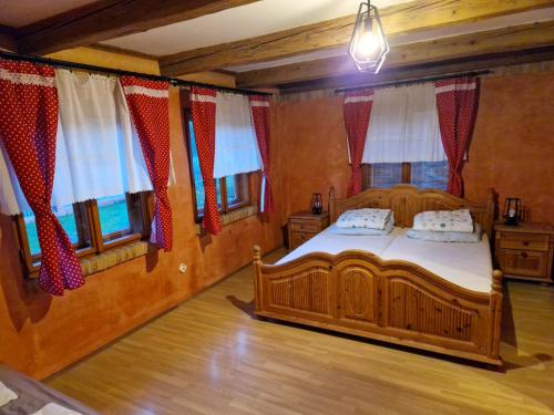 a bedroom with a wooden bed in a room with windows at chalupa Stritez in Střítež