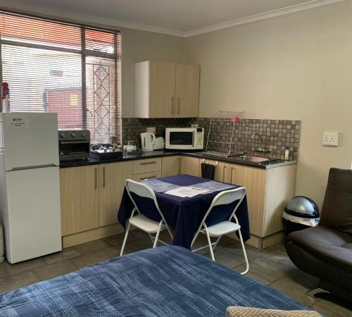 a small kitchen with a table and a refrigerator at Midway En Route in Harrismith