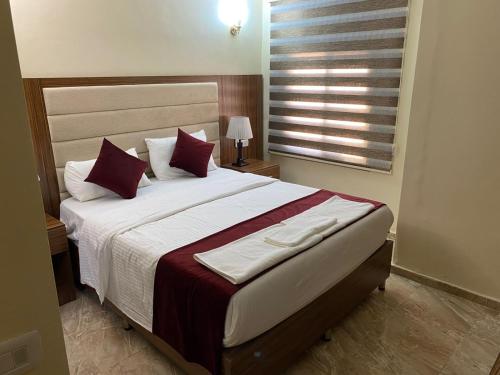 a bedroom with a large bed with red pillows at Sunset Hotel in Wadi Musa