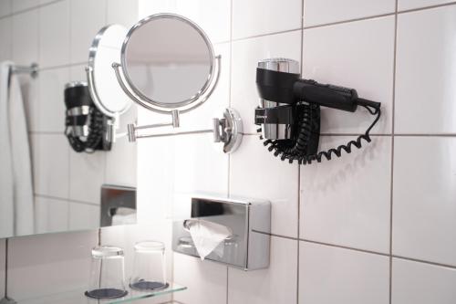 a bathroom with a hair dryer and a mirror at K+K Hotel Fenix in Prague