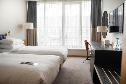 a hotel room with two beds and a desk at K+K Hotel Fenix in Prague
