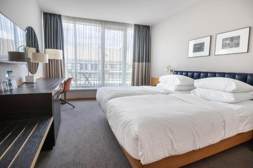 a hotel room with a large bed and a desk at K+K Hotel Fenix in Prague