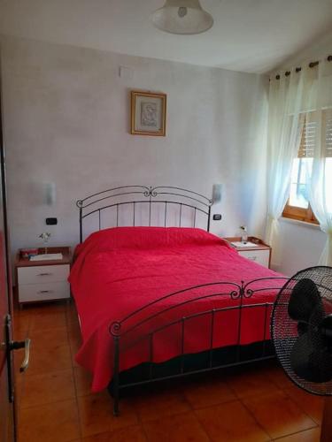 a bedroom with a red bed with a red blanket at Villa S'Oliariu in Martis