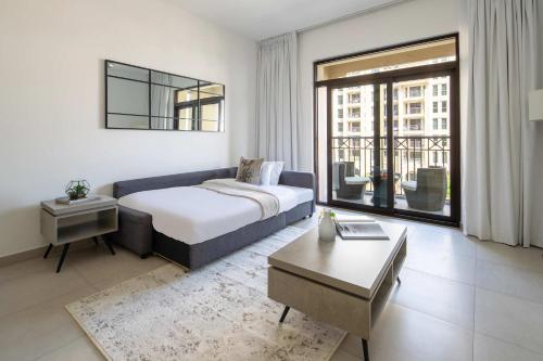 a bedroom with a king sized bed and a table at Frank Porter - Lamtara 3 in Dubai