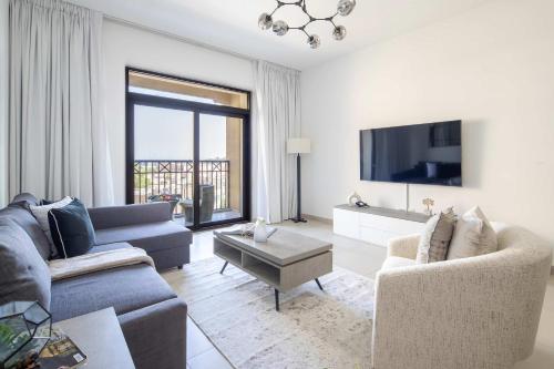 a living room with two couches and a tv at Frank Porter - Lamtara 3 in Dubai